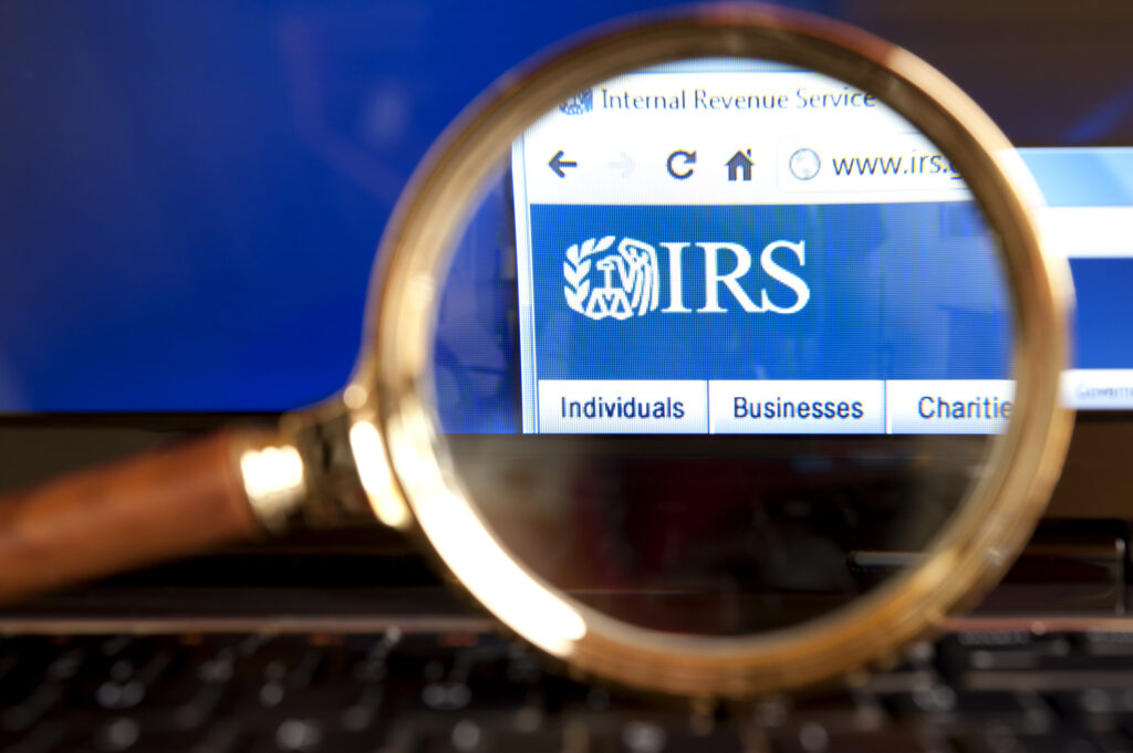 irs logo photo IRS website through a magnifying glass